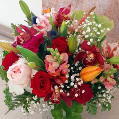 Technicolour - A stunning handtied bouquet. Created using a mix of vibrant seasonal flowers in red, pink and white with complimentary foliage. Hand delivered with care in and around Cape Town by Shirleys Flower Designs.
