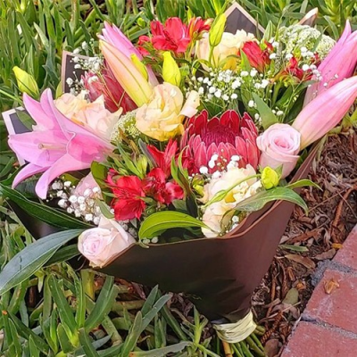 Brighten Your Day - An amazing handtied bouquet created using a mix of pink, red, white and green flowers with complimentary foliage. Hand delivered with care in and around Cape Town by Shirleys Flower Designs.