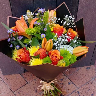 Perfect Sunset - A stunning handtied bouquet created using orange roses, yellow and white flowers with complimentary foliage. Hand delivered with care in and around Cape Town by Shirleys Flower Designs.